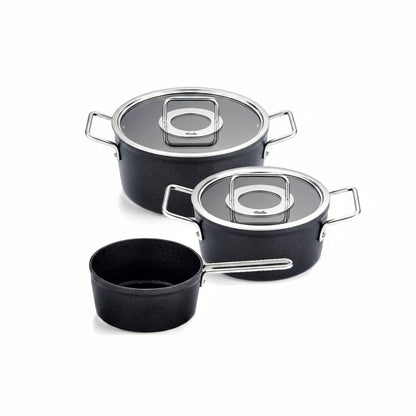 Set of black cookware with lids on a white background